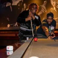 Two alumni playing pool at the event.